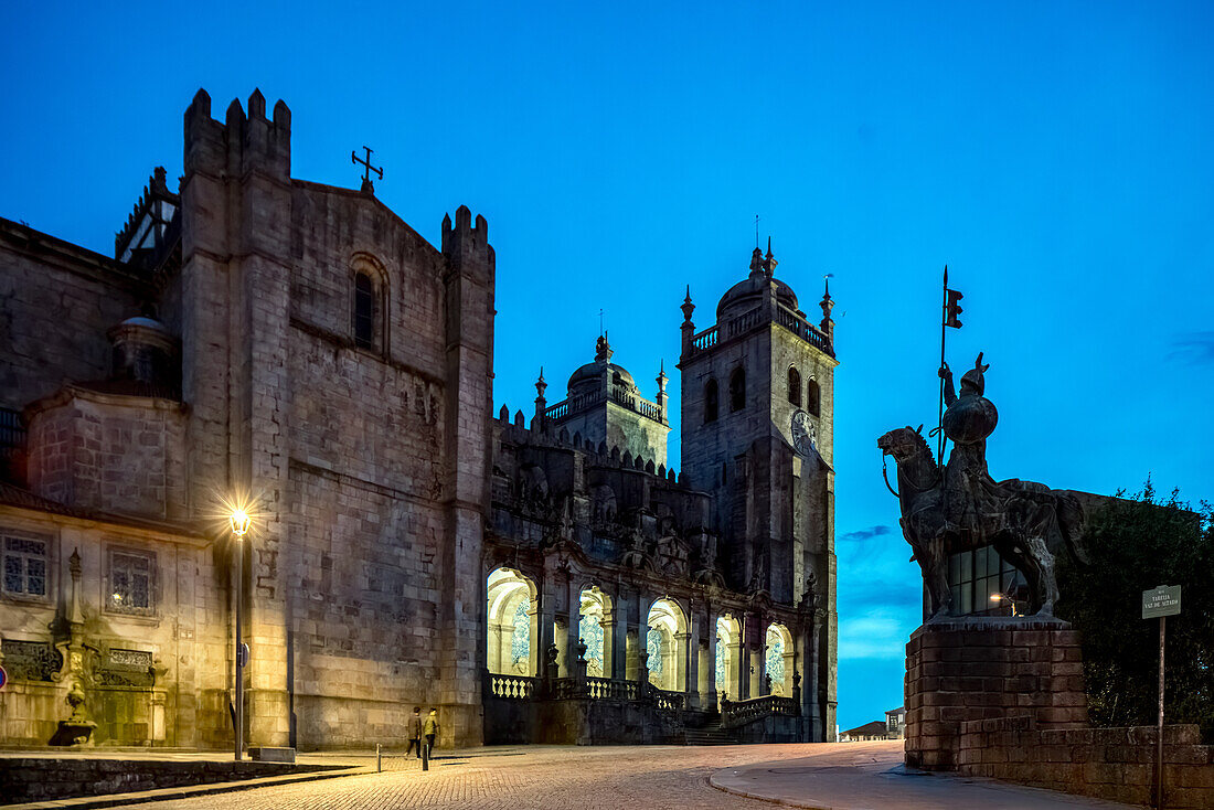 Evening view of Terreiro da Se Square featuring the Porto Cathedral and the statue of Vimara Peres, capturing the historic charm of Porto, Portugal.