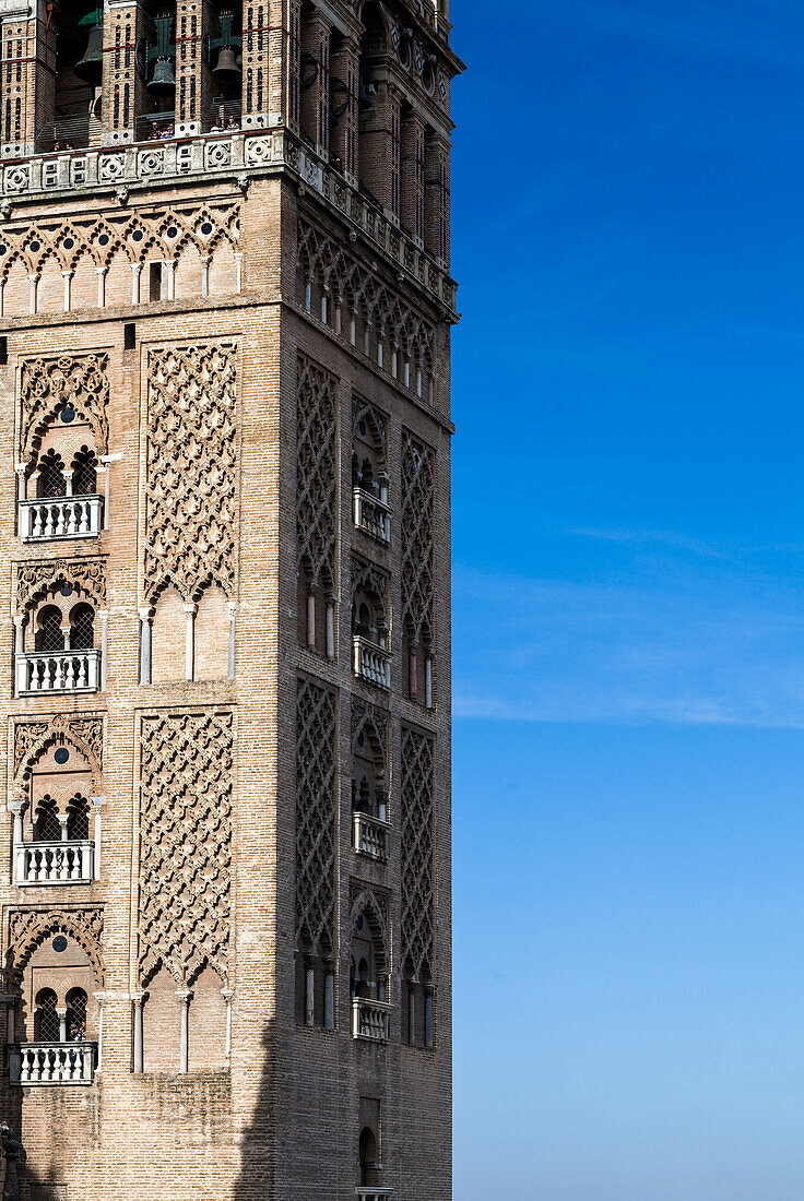 Der ikonische Giralda-Turm erhebt sich majestätisch vor einem klaren blauen Himmel und präsentiert komplizierte Designs und eine reiche Geschichte in Sevilla, Spanien