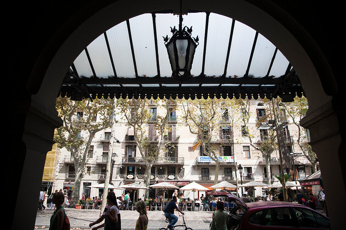 People stroll along Las Ramblas, enjoying the vibrant atmosphere outside the Liceu Theatre.