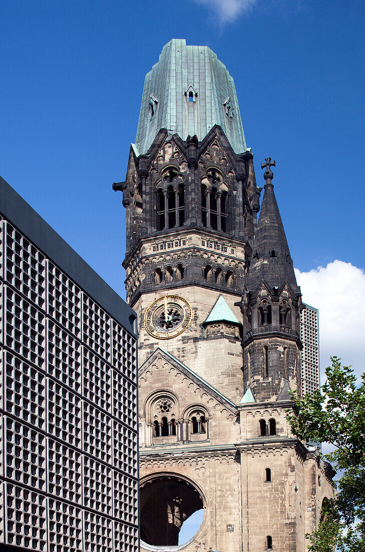 Die Kaiser-Wilhelm-Gedächtniskirche steht stolz neben modernen Gebäuden und unterstreicht die Mischung aus Geschichte und zeitgenössischem Design in Berlin\