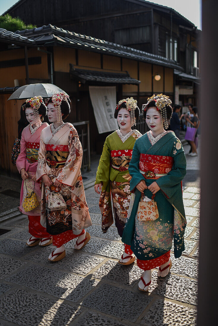 Eine Gruppe als Maikos verkleideter Frauen in den Straßen von Kyoto, Japan