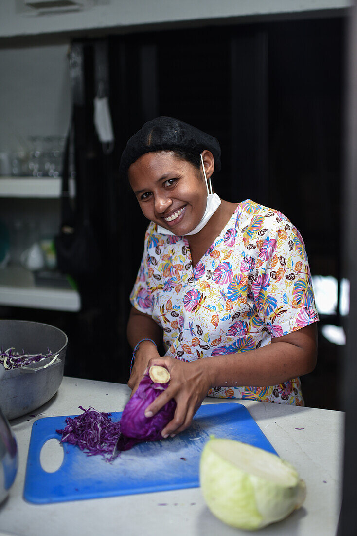 Portrait of young female cook cutting vegetables in Santa Marta, Colombia