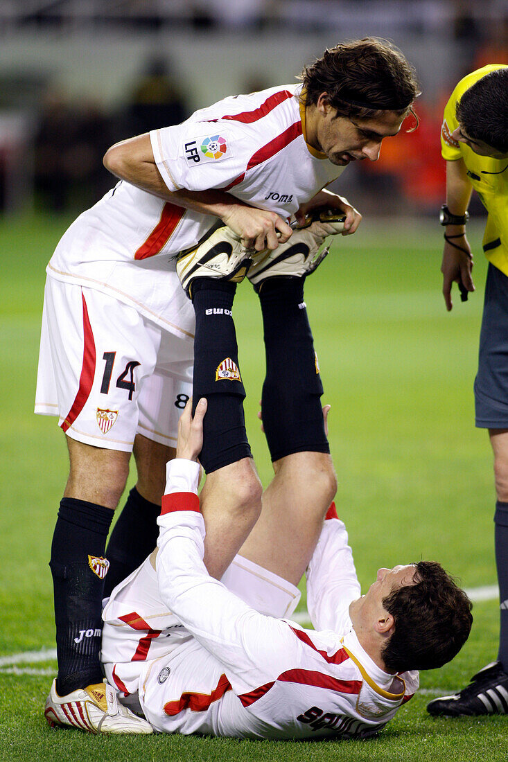 Seville, Spain, Nov 30 2008, Escudé is attending to his injured teammate Squillaci after a tackle in a league match held at Sánchez Pizjuán Stadium in 2008.