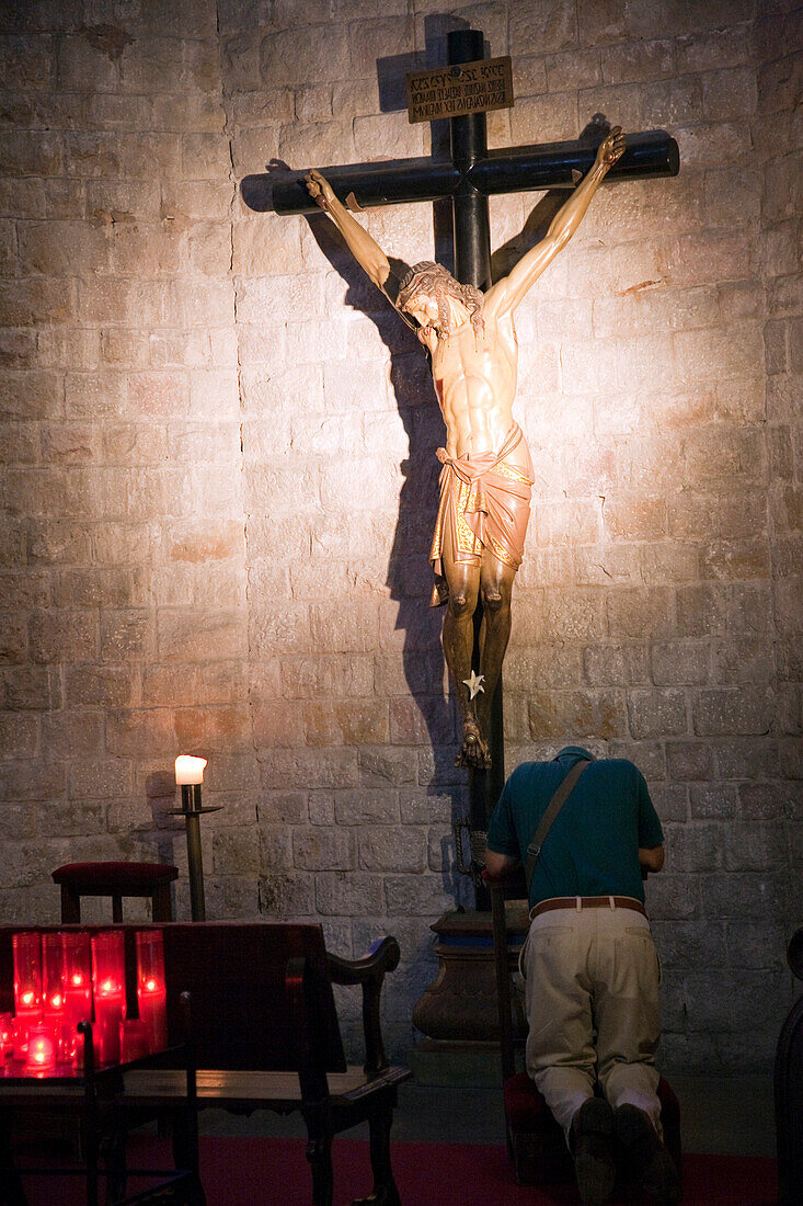 Barcelona, Spain, Sept 4 2008, A man engages in deep prayer, kneeling before a crucifix in Santa María del Mar, capturing a moment of devotion in Barcelona.