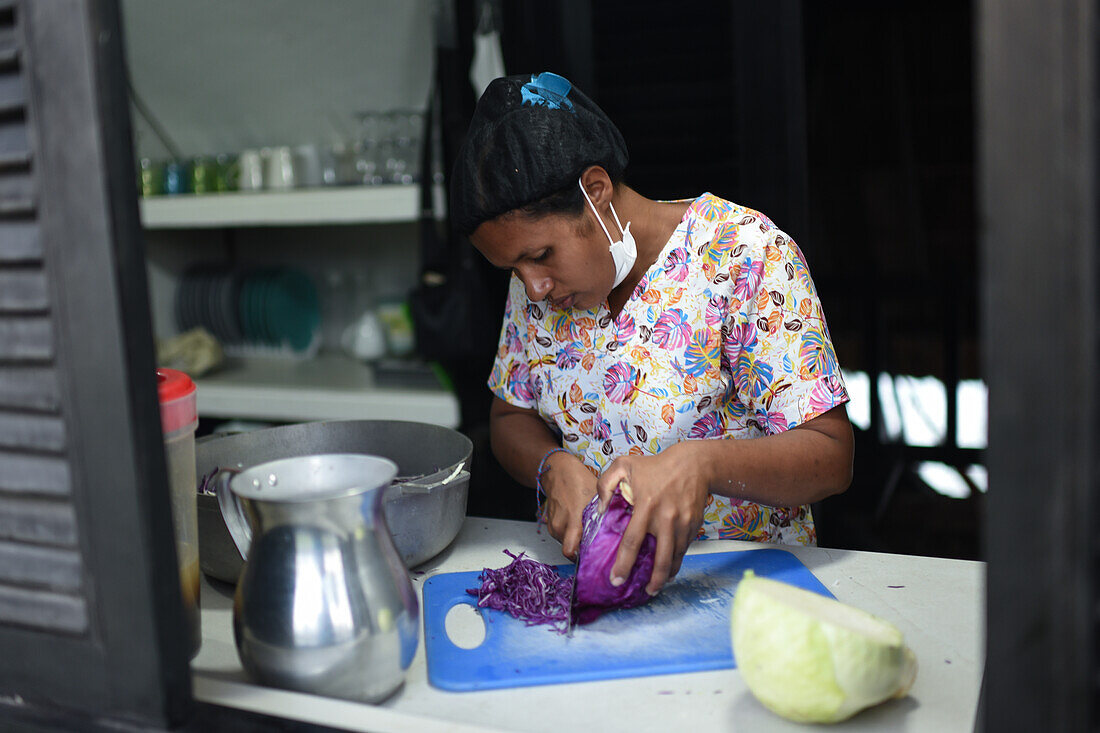 Portrait of young female cook cutting vegetables in Santa Marta, Colombia