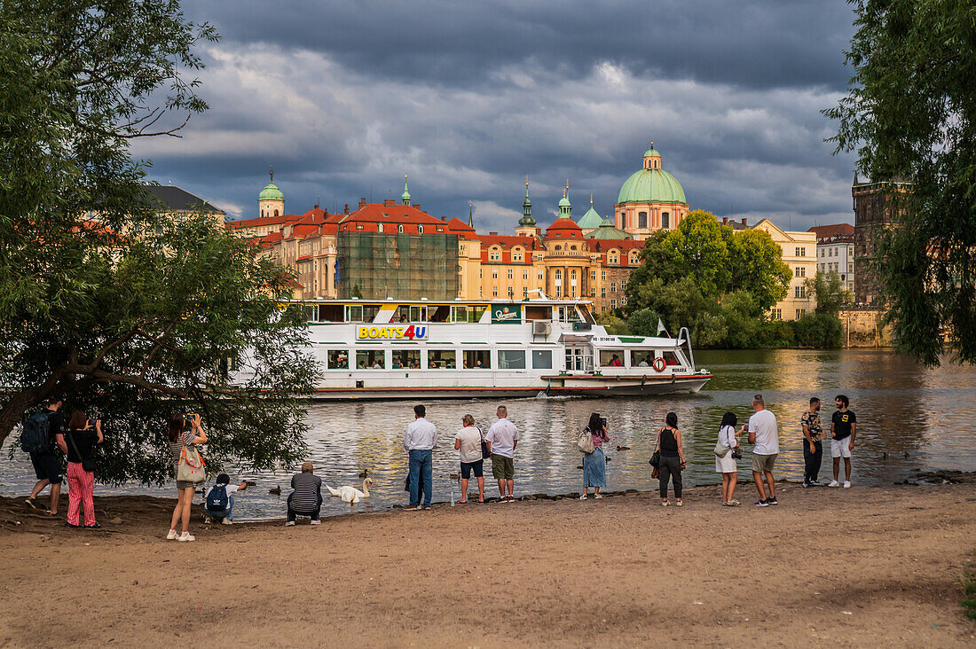 People enjoying themselves on the Vltava river bank, Prague