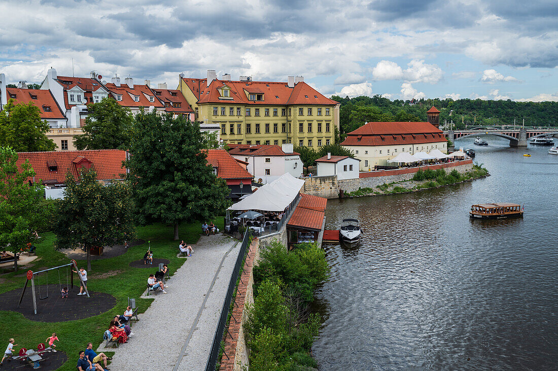 Left bank of Vltava river in Prague with mouth of Certovka stream, old houses and former complex of Herget's brickworks, now a restaurant and museum