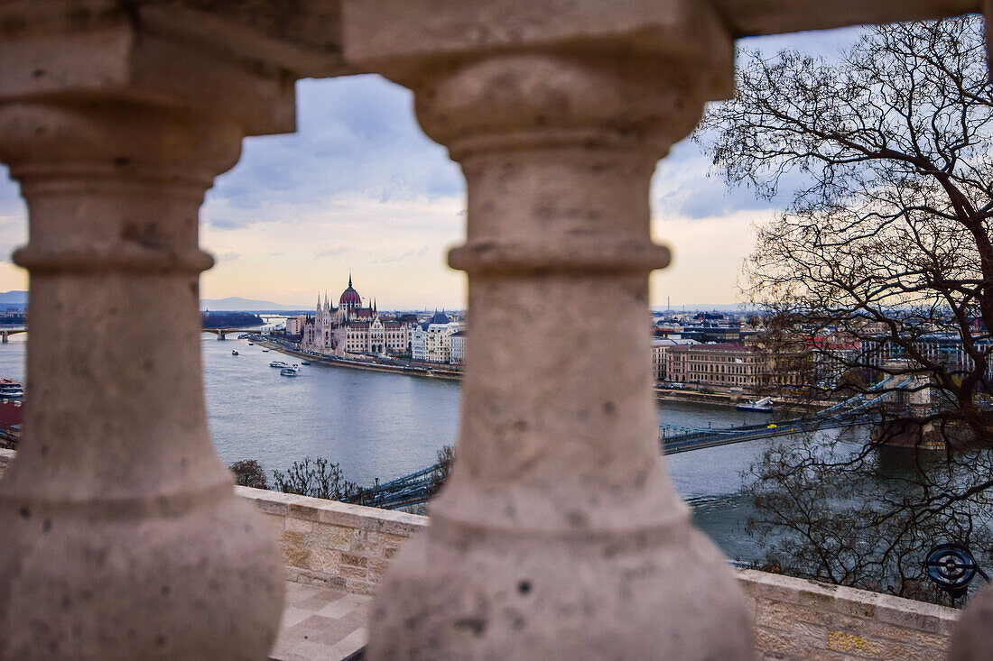 Parliament building and Danube River, viewed through old columns, Budapest, Hungary, Europe