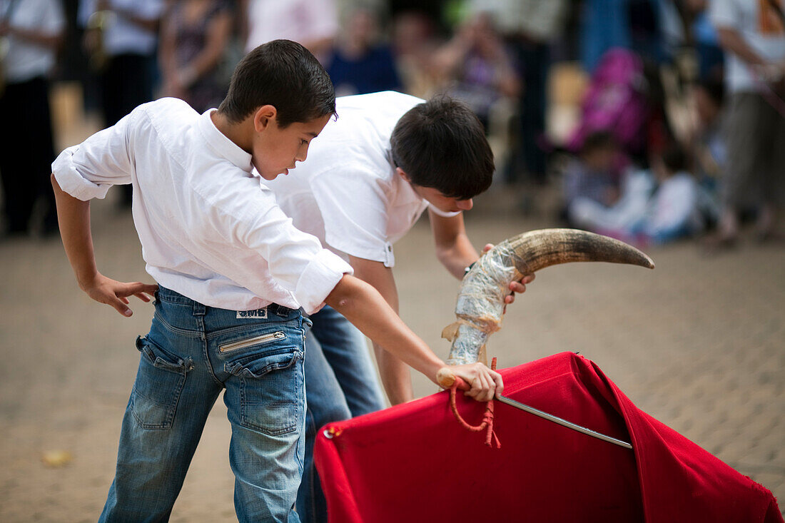 Seville, Spain, June 11 2009, Young bullfighter trainees engage in toreo de salon at Alameda de Hercules square, showcasing their skills and techniques.