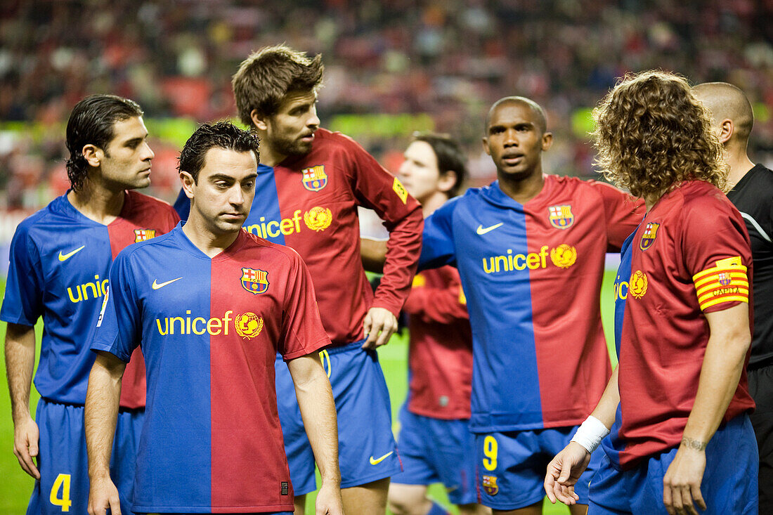 Seville, Spain, Nov 30 2008, Barcelona players, including Xavi and Piqué, strategize during their match against Sevilla in 2008, resulting in a 3-0 victory.