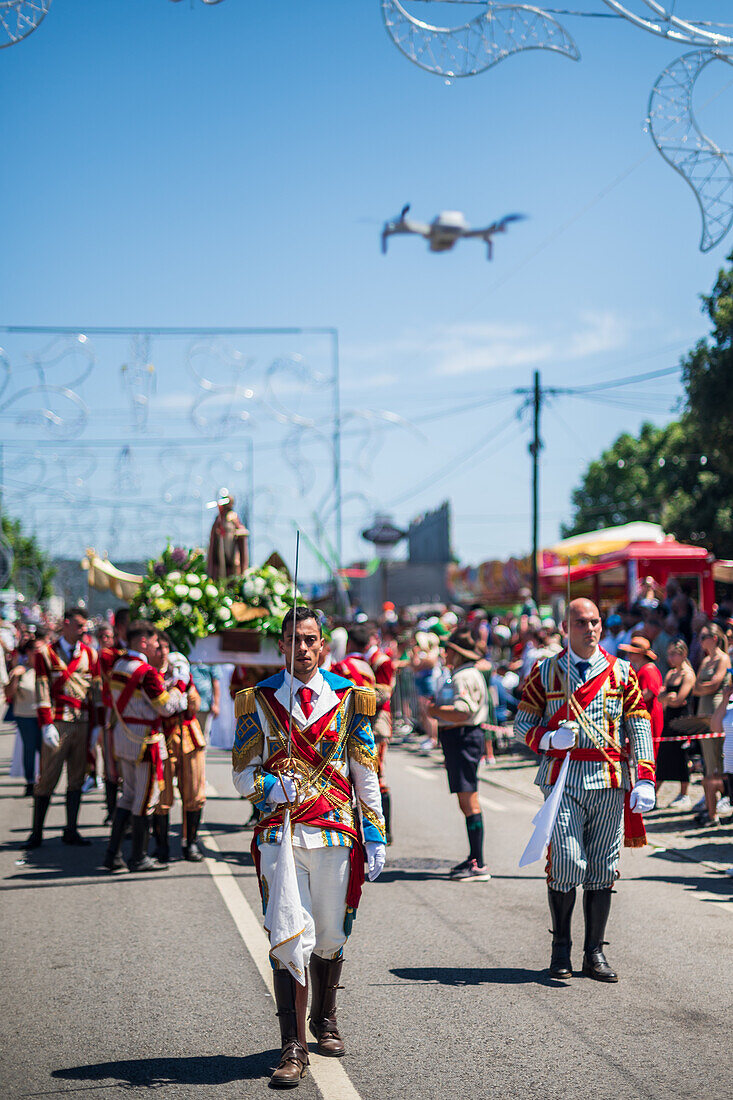 Drone capturing the religious procession finishing at São João Baptista Church during the Festival of Saint John of Sobrado, also known as Bugiada and Mouriscada de Sobrado, takes place in the form of a fight between Moors and Christians , locally known as Mourisqueiros and Bugios, Sao Joao de Sobrado, Portugal