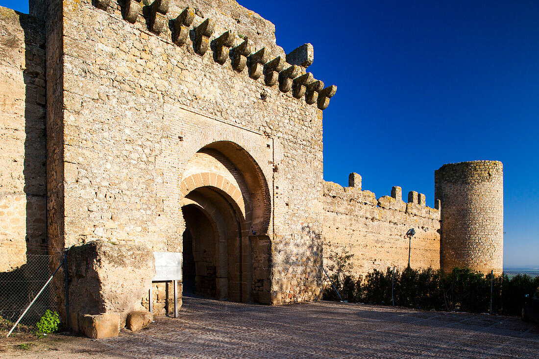 Entdecken Sie den beeindruckenden Eingang des ehemaligen maurischen Alcazar in Carmona, der unter einem strahlend blauen Himmel alte Architektur zeigt