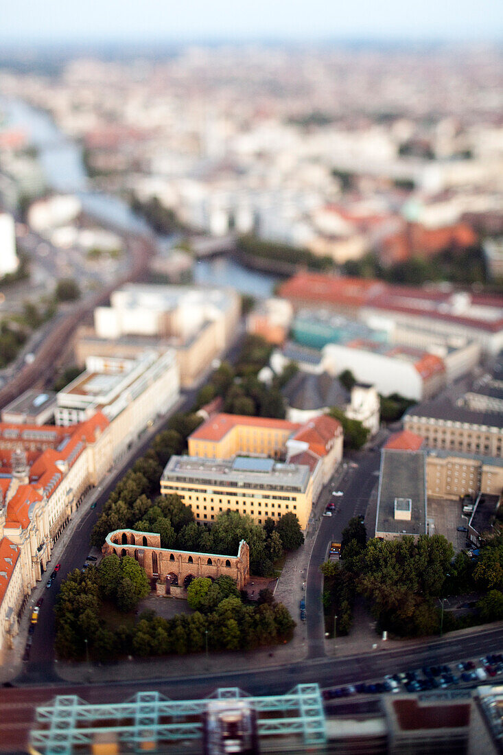 The ruins of Franziskaner-Klosterkirche appear miniature in this aerial view of Berlin Mitte, showcasing the city\'s distinct architecture.