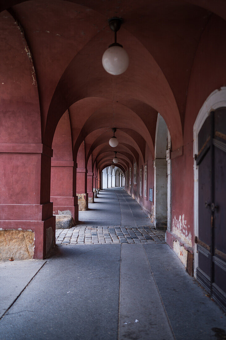 A narrow arched passage painted dark red in Old Prague