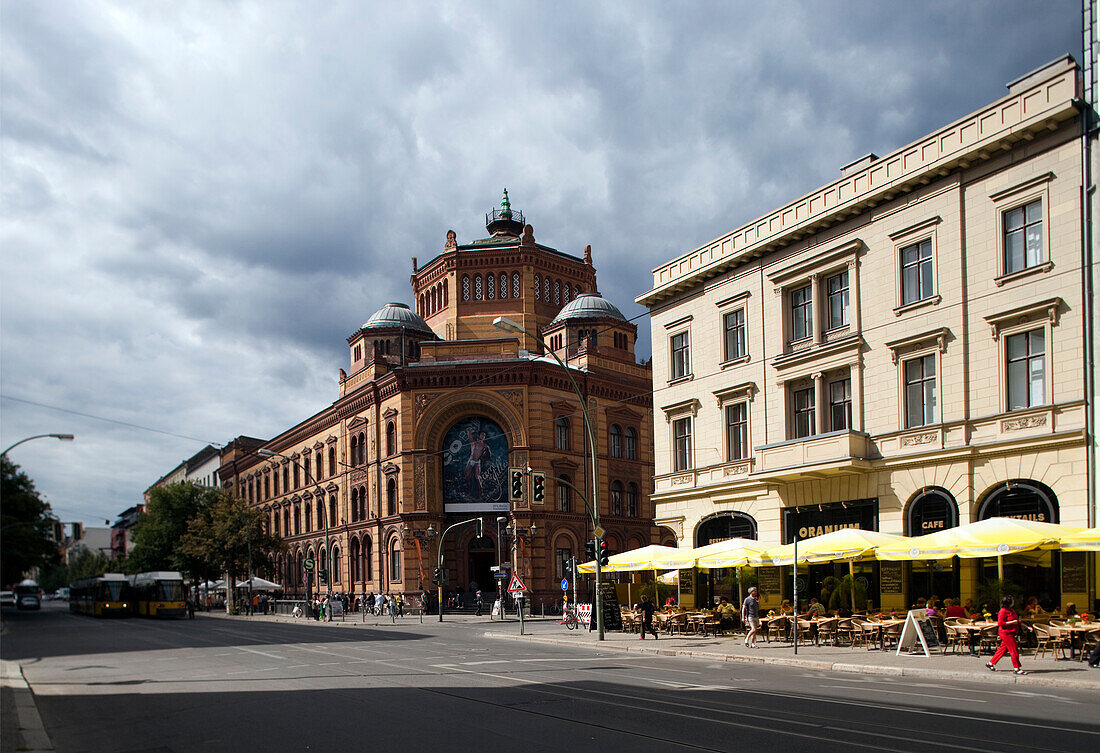 The historic Postfuhramt building stands proudly amid modern life on Oranienburger Strasse, featuring outdoor dining in lively Berlin.