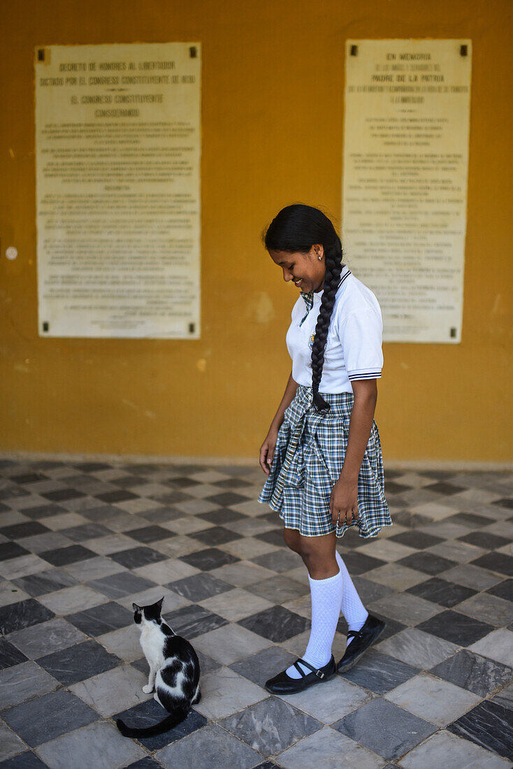 Porträt eines jungen Schulmädchens mit Katze in der Quinta de San Pedro Alejandrino, wo Simon Bolivar seine letzten Tage verbrachte, Santa Marta, Kolumbien