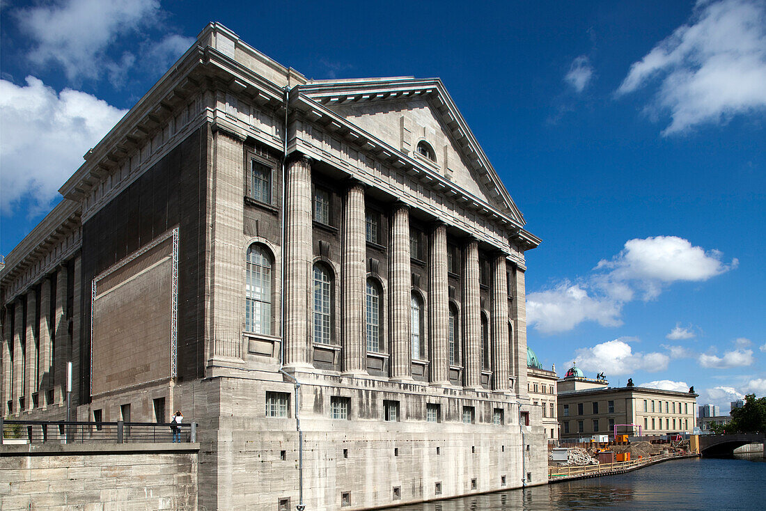 Das historische Pergamonmuseum steht majestätisch am Wasser in Berlin und präsentiert seine großartige Architektur unter einem hellen Himmel