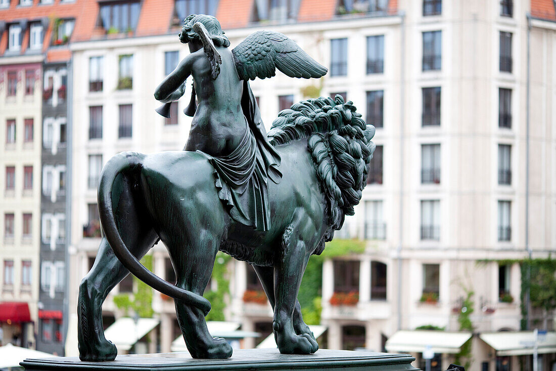 Eine detaillierte Bronzestatue, die eine geflügelte Figur auf einem Löwen darstellt, steht auf dem Gendarmenmarkt in Berlin, in der Nähe des historischen Konzerthauses