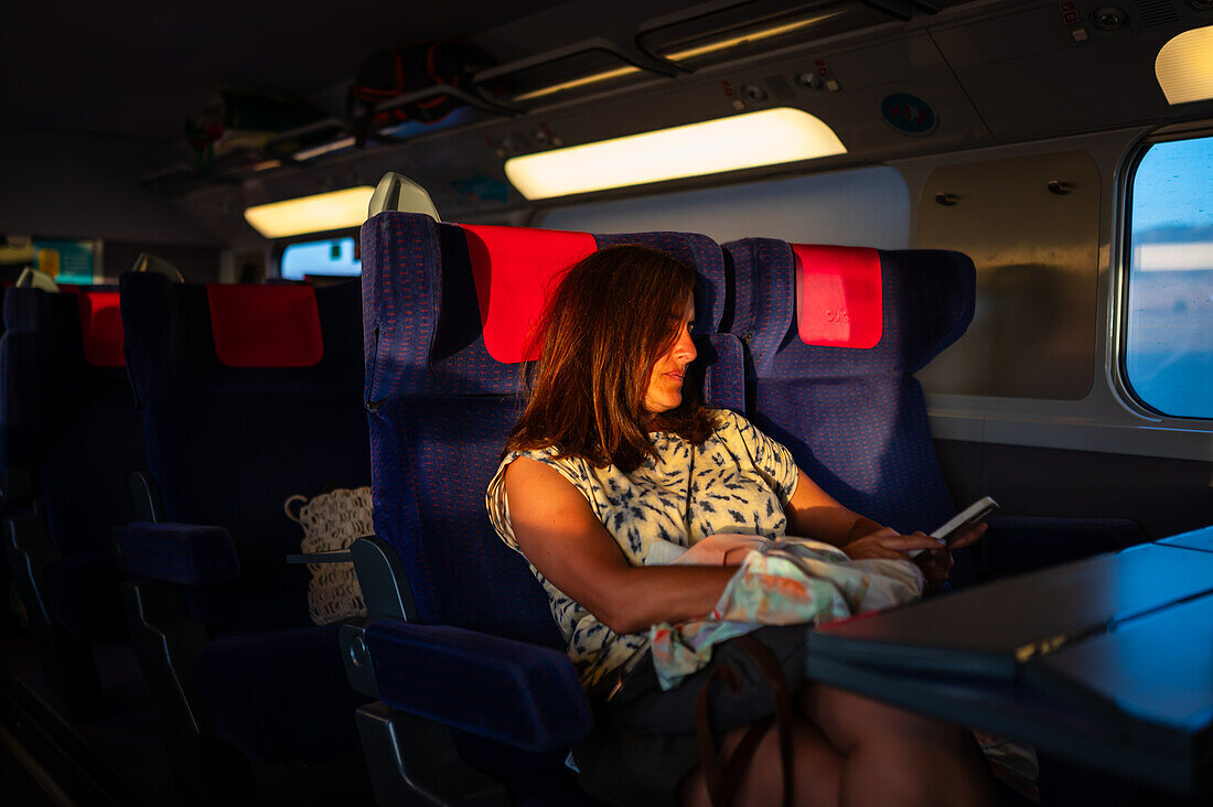 Woman using her smartphone while traveling in the AVE high speed train, Spain