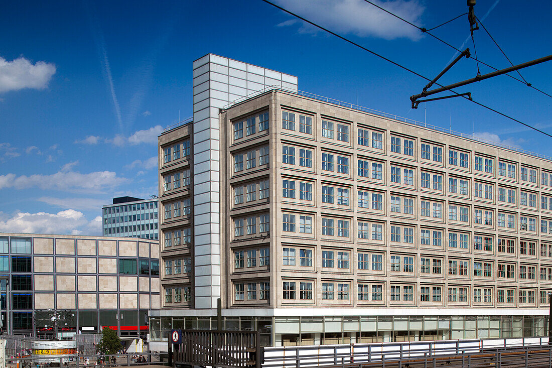 The vibrant Alexanderplatz is bustling with activity, showcasing modern architecture and a busy atmosphere in Berlin.