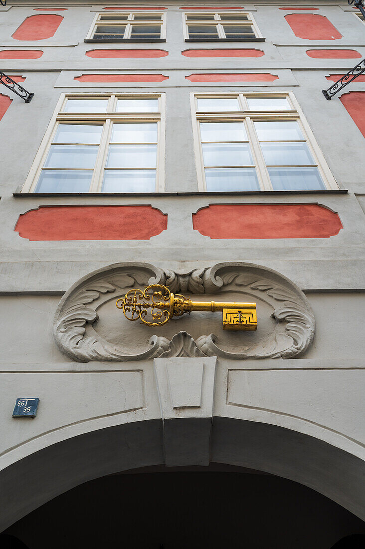 A distinct golden key house sign on the wall in Prague