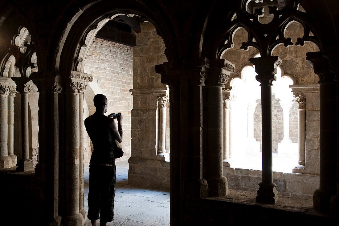 Barcelona, Spain, Sept 4 2008, A visitor stands in the cloister of Sant Pau del Campo, capturing its historical architecture during a serene moment.