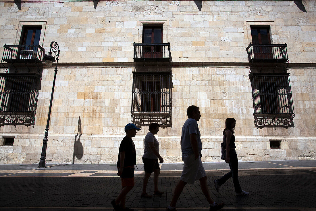 Leon, Spain, Aug 21 2008, Visitors stroll leisurely along Calle Ancha, admiring the southern facade of the historic Palacio de los Guzmanes in León.