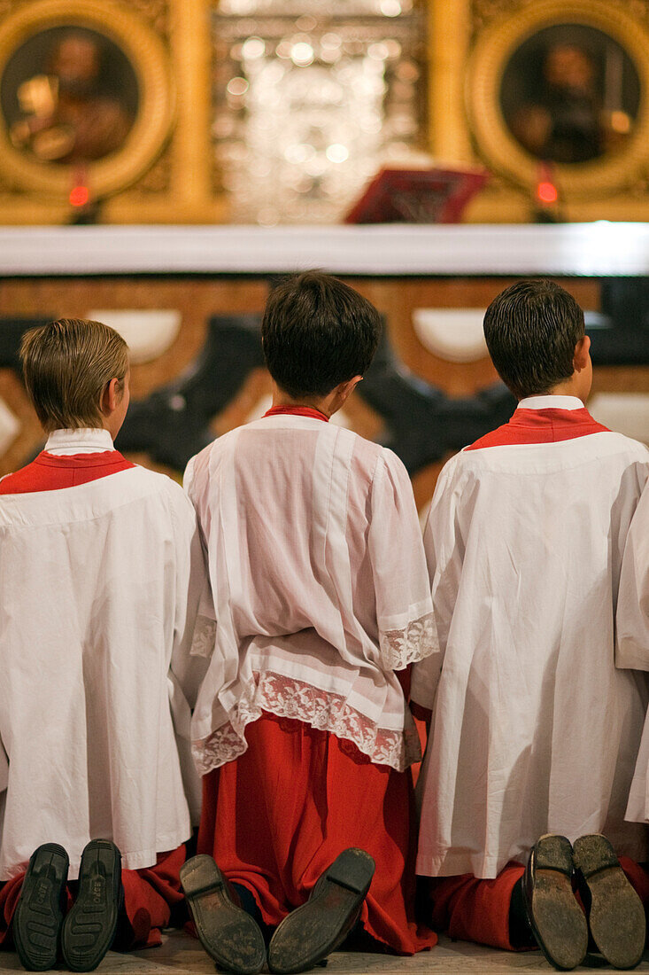 Ministranten knien im Gebet am Ende der Fronleichnamsprozession in der Kirche Sagrario in Sevilla während eines feierlichen Moments im Jahr 2009