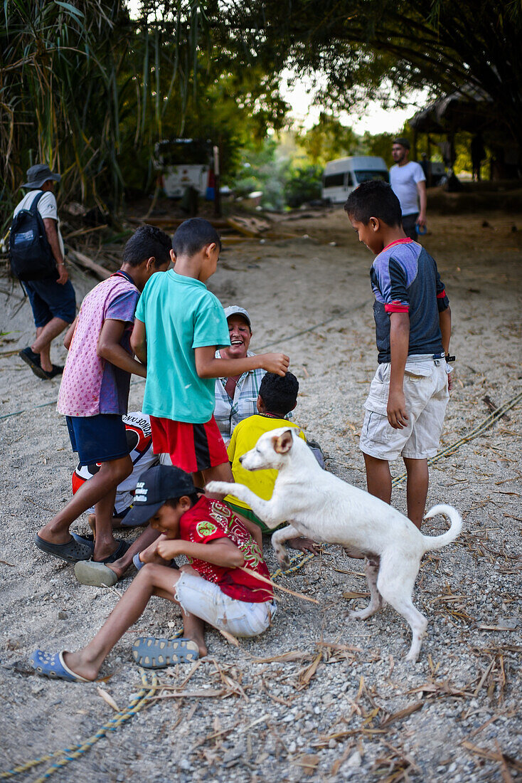 Group of playful local kids having fun with a foreigner woman, Santa Marta, Colombia