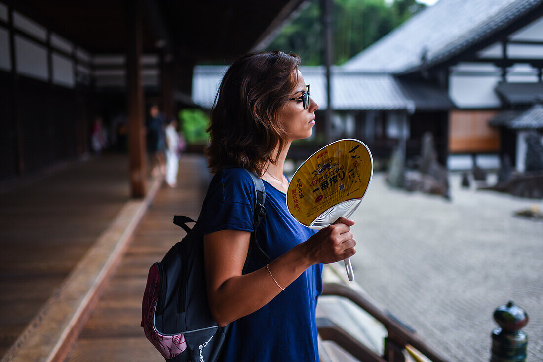 Junge Frau fächelt sich im Tofukuji-Tempel in Kyoto, Japan