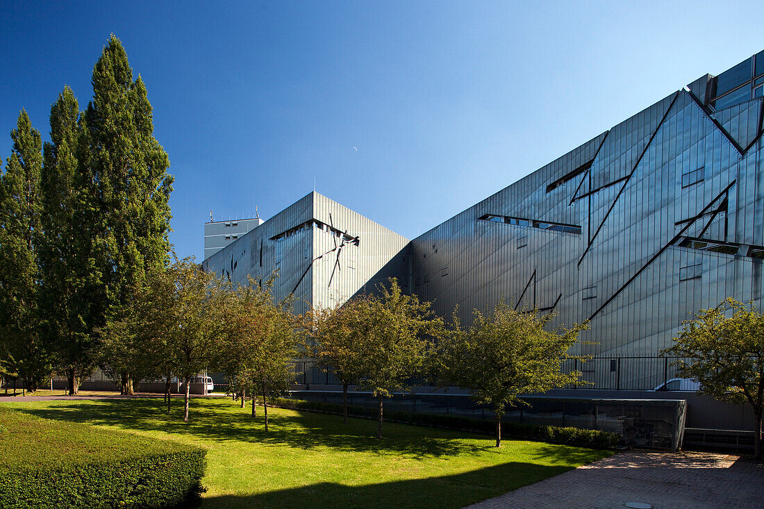 Berlin, Germany, July 27 2009, The Jewish Museum in Berlin showcases striking modern design with angular forms against a clear blue sky, surrounded by greenery.