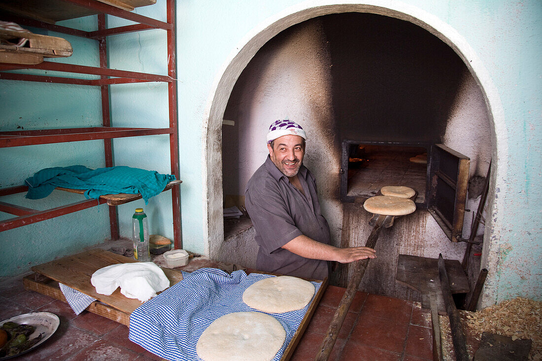 Chefchaouen, Morocco, July 3 2007, A baker skillfully prepares bread in a communal oven, showcasing the local culinary tradition in the town of Chefchaouen, northern Morocco.