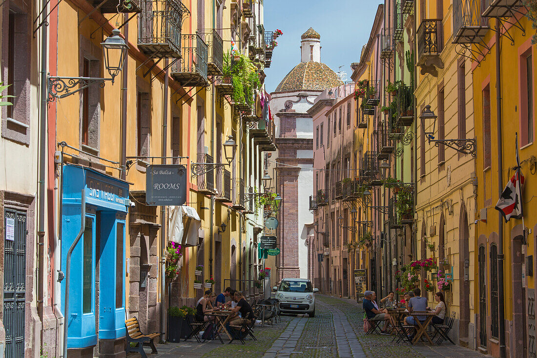 Blick entlang des gepflasterten Corso Vittorio Emanuele II im historischen Viertel Sa Costa, bunte Kachelkuppel der Kathedrale prominent, Bosa, Oristano, Sardinien, Italien, Mittelmeer, Europa