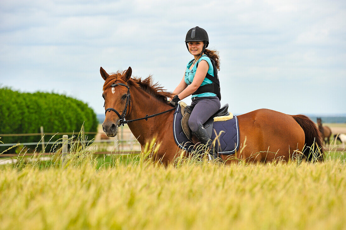 Jugendlicher reitet auf Pony in der Landschaft, Departement Eure et Loir, Region Centre-Val de Loire, Frankreich, Europa