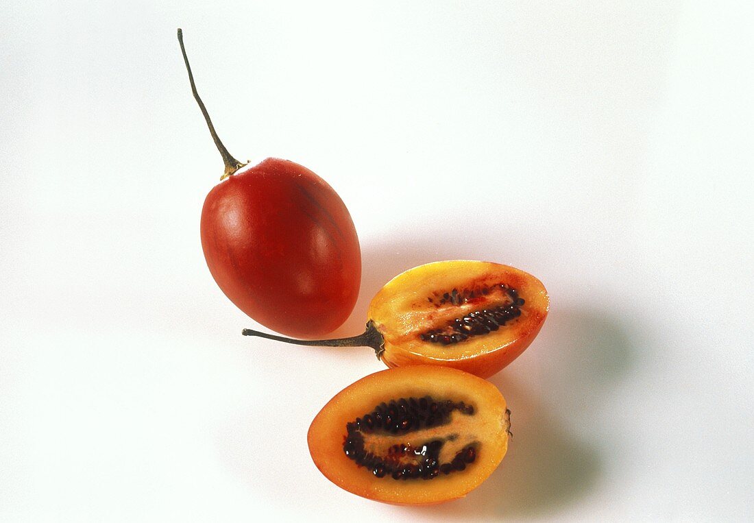 Whole and halved tree tomato (Tamarillo)