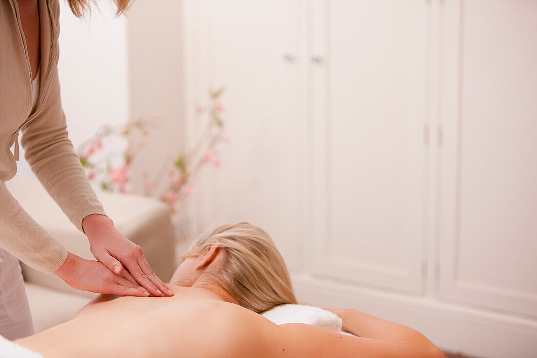 Masseurin gibt einer Frau eine Rückenmassage