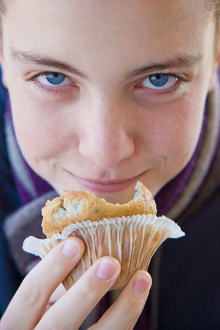 Close up of a boy eating a muffin