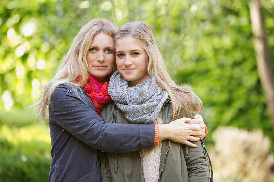 Mutter umarmt Tochter im Freien