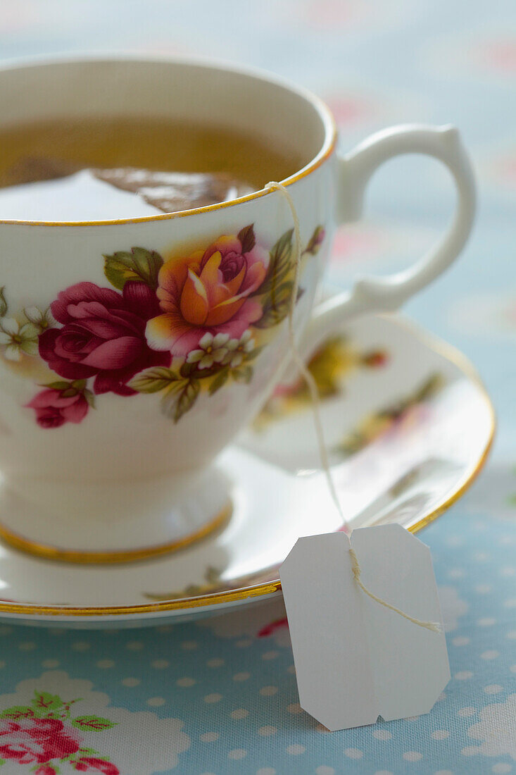 Teetasse mit Blumenmuster und grünem Tee