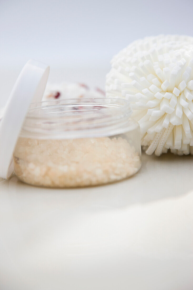 Close up of a jar of bath salts and sponge