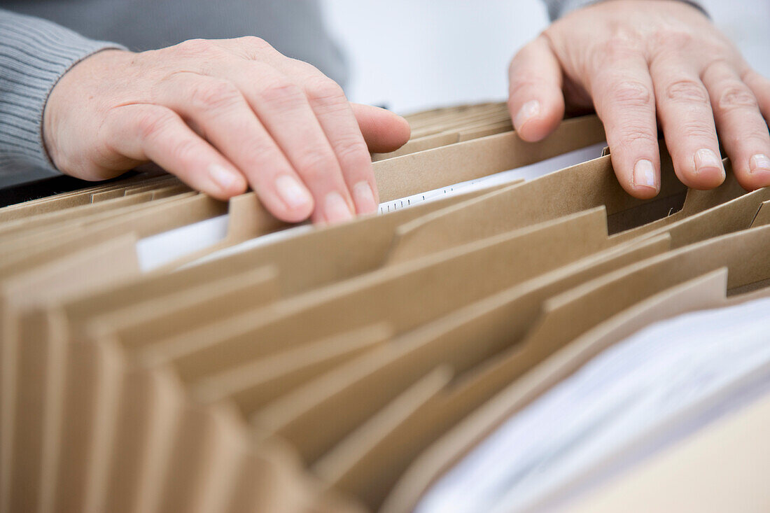 Close up of a woman hands flicking through a file folder