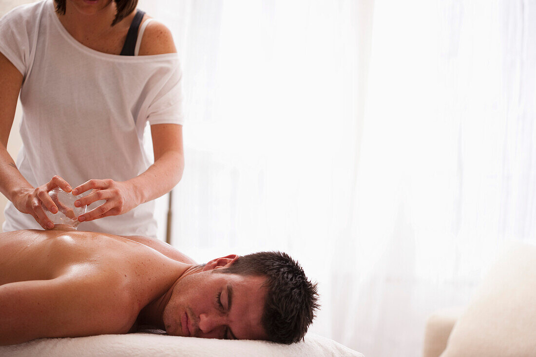 Man receiving cupping therapy on his back