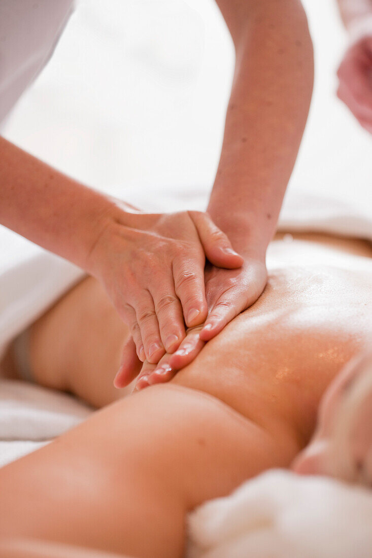 Close up of a masseur hands giving a woman a massage