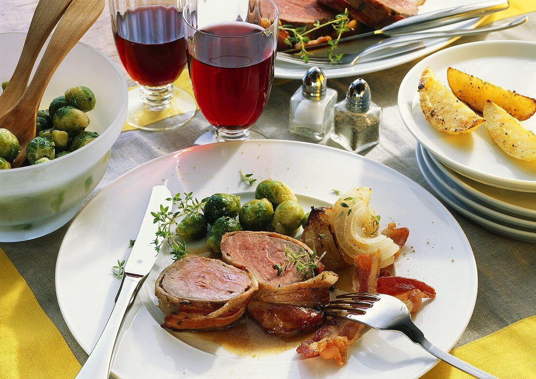 Roast beef fillet in bacon case & Brussels sprouts on plate