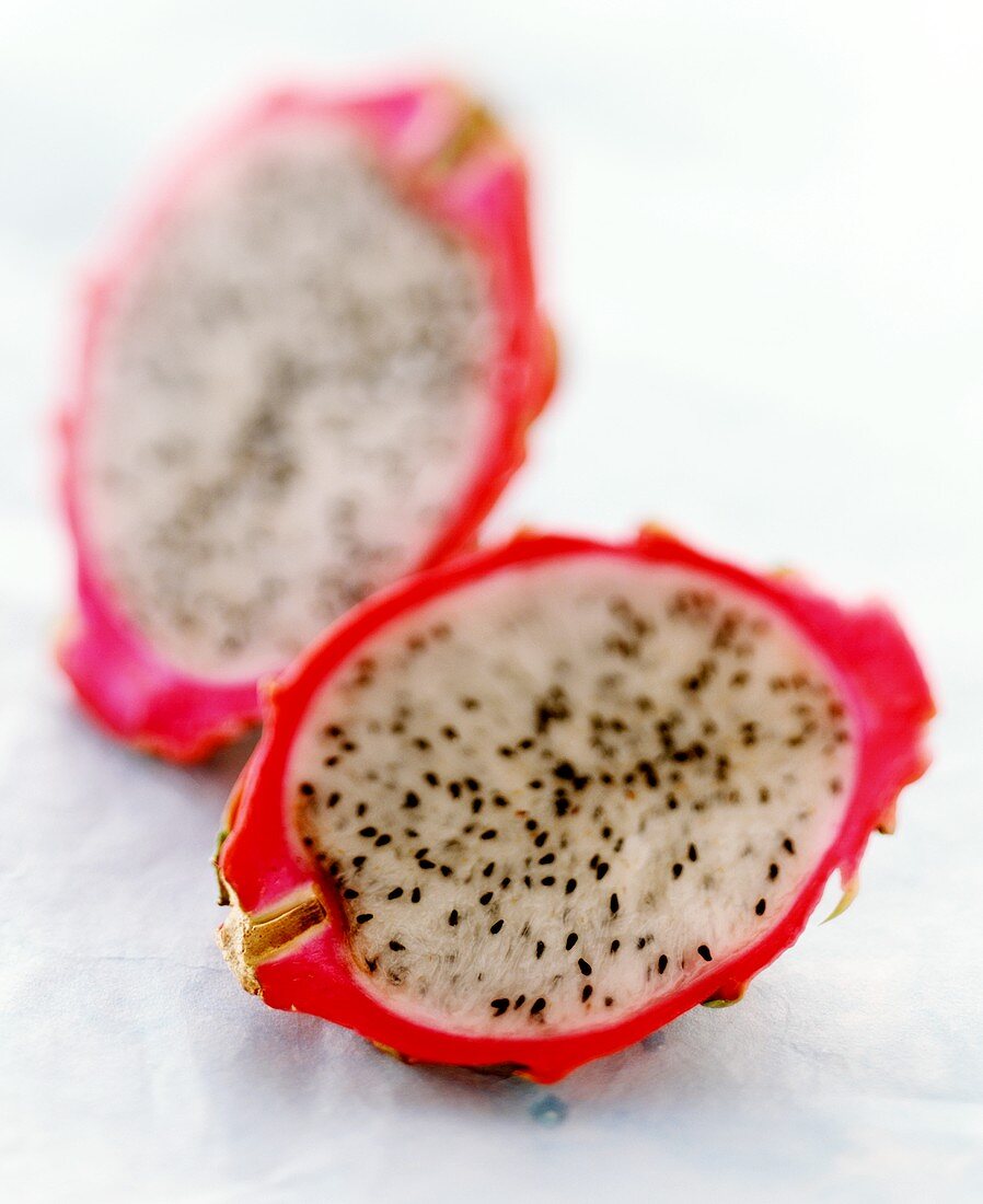 Two pitahaya halves on pale-blue background