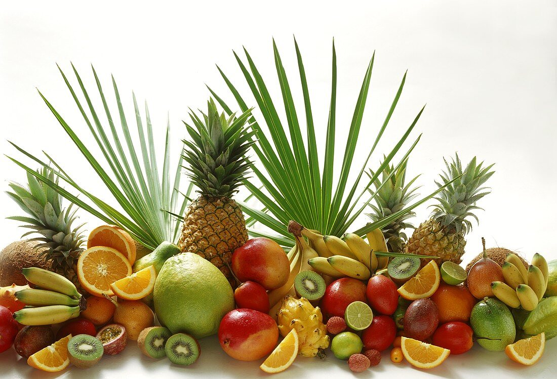 Exotische Früchte mit Zitrusfrüchten; Deko: Palmenblätter