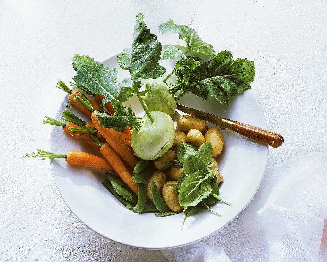 Carrots, kohlrabi, pods, potatoes, spinach in bowl