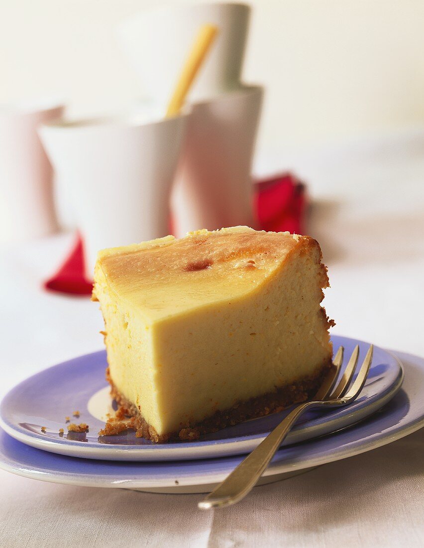 A piece of New York cheesecake on cake plate