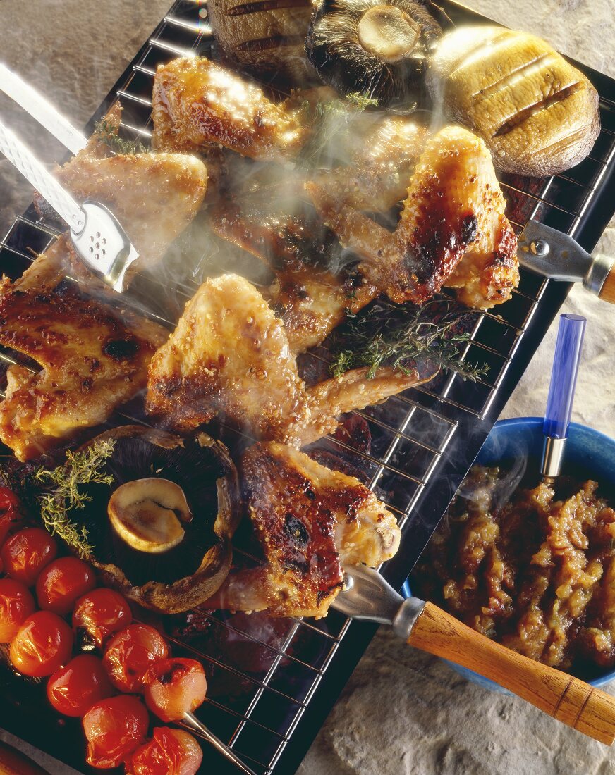 Grilled chicken wings & vegetables on smoking grill