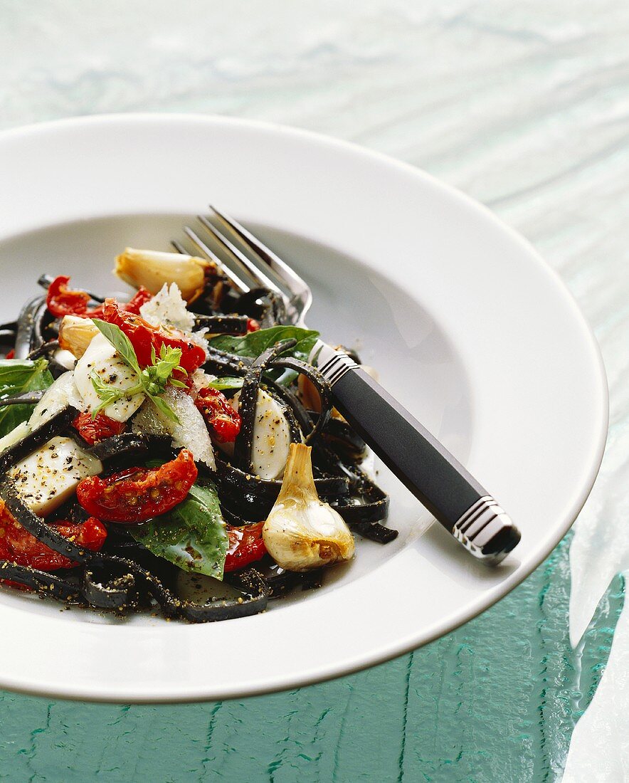 Tintenfischnudel-Salat mit Mozzarella, Tomaten und Knoblauch